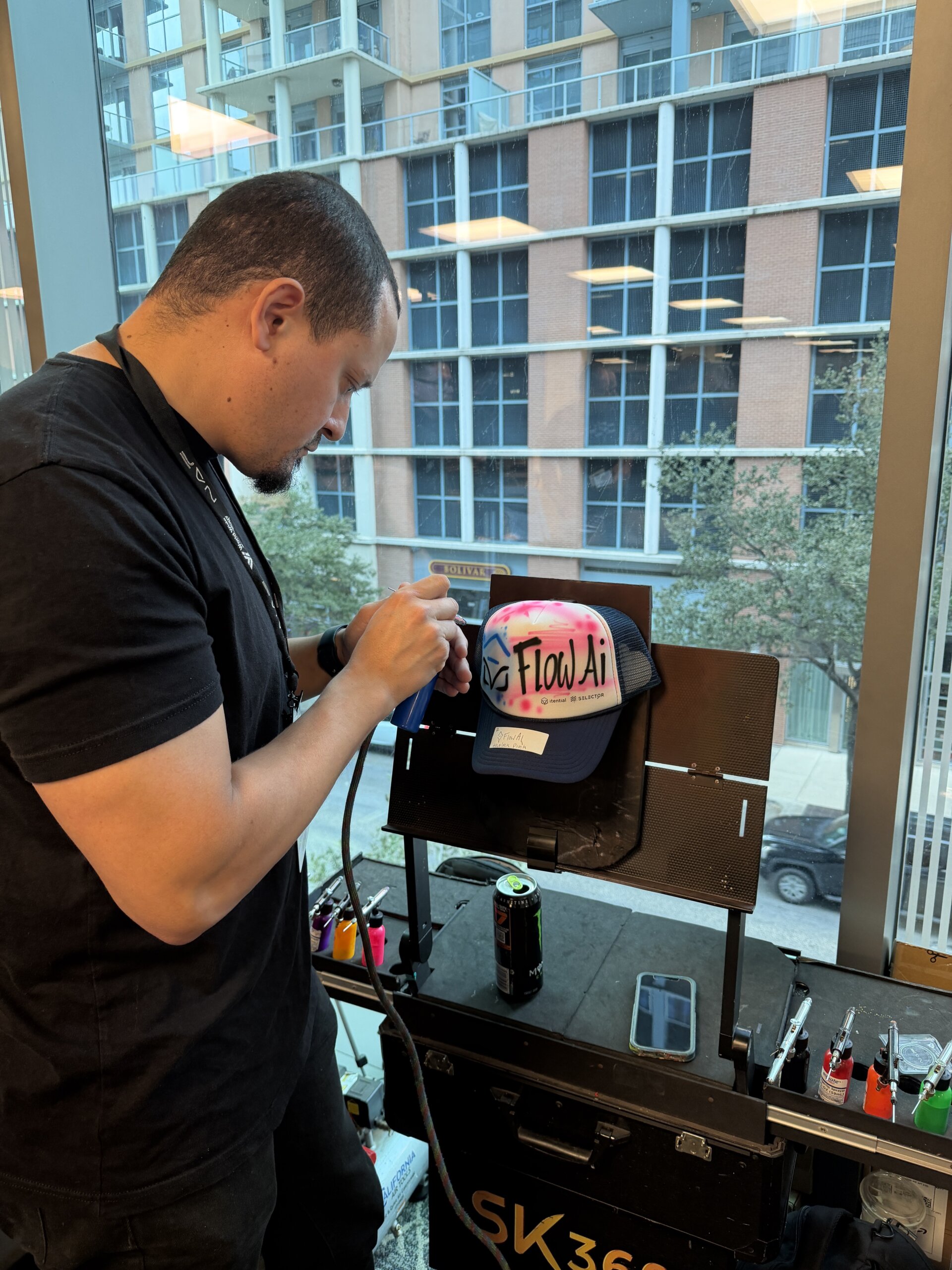 graffiti artists drawing an itential logo with flowAI on a hat at autocon 4